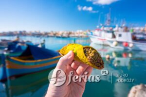 Maltese pistachio cannoli in hand at the fishing port of Marsaxlokk