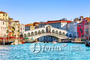 View of Grand Canal with Rialto Bridge and gondoliers in Venice, Italy. Landscape with  Rialto Bridge and gondola on the Grand Canal in Venice, Italy, Europe.