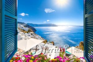 Widok przez otwarte okno z okiennicami bielonej wioski Oia wznoszącej się nad błękitnym Morzem Egejskim i kalderą na wyspie Santorini w Grecji.